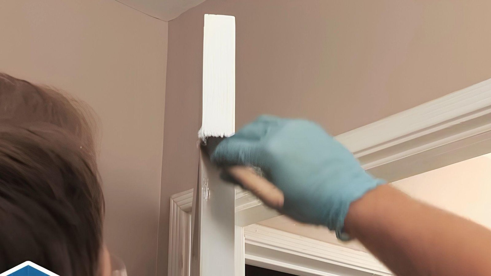 Painting the sanded edge of a white door to restore its finished appearance after repairs.