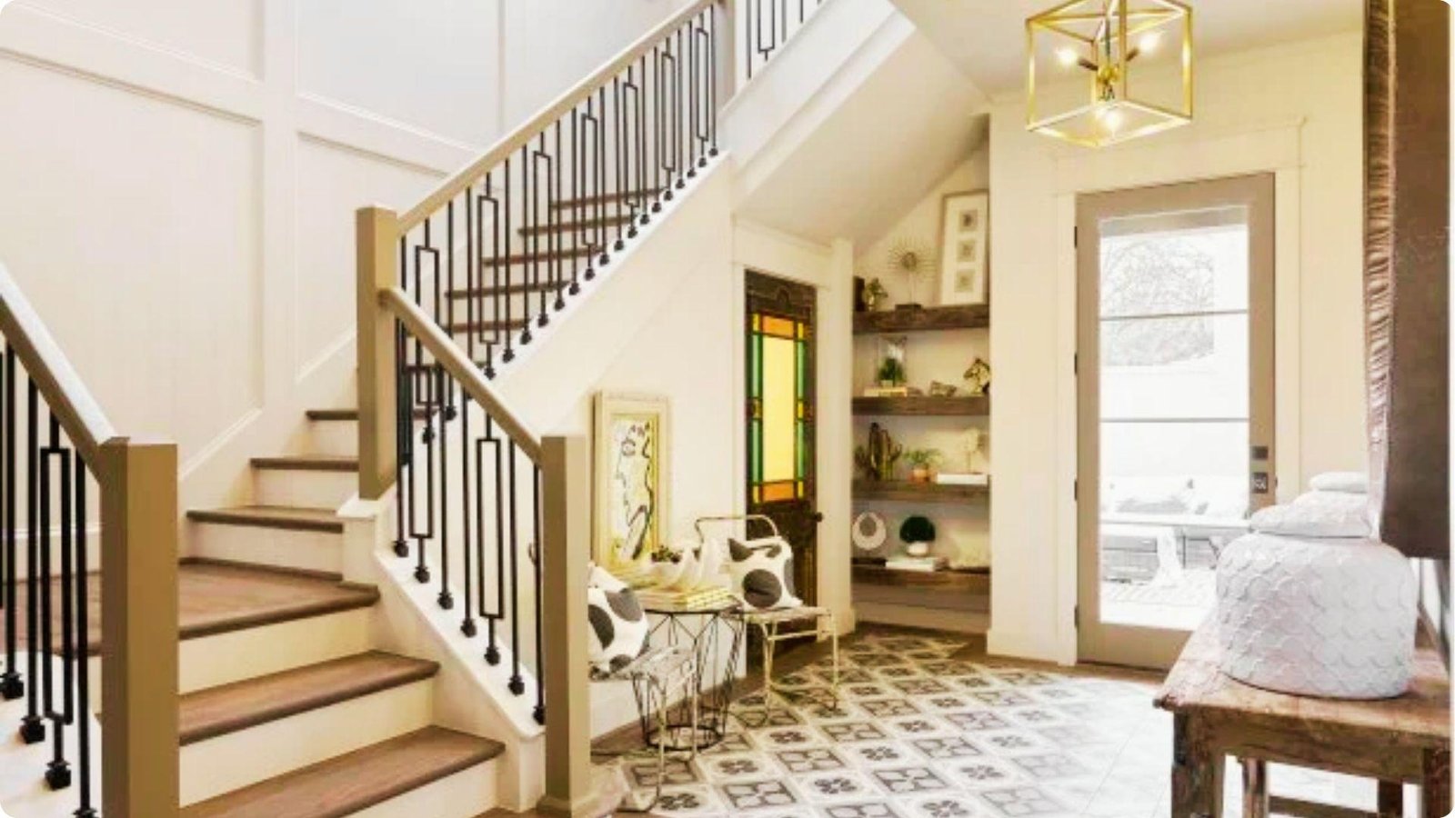 A staircase entryway uses patterned tile flooring and built-in shelves under the stairs to define the space.