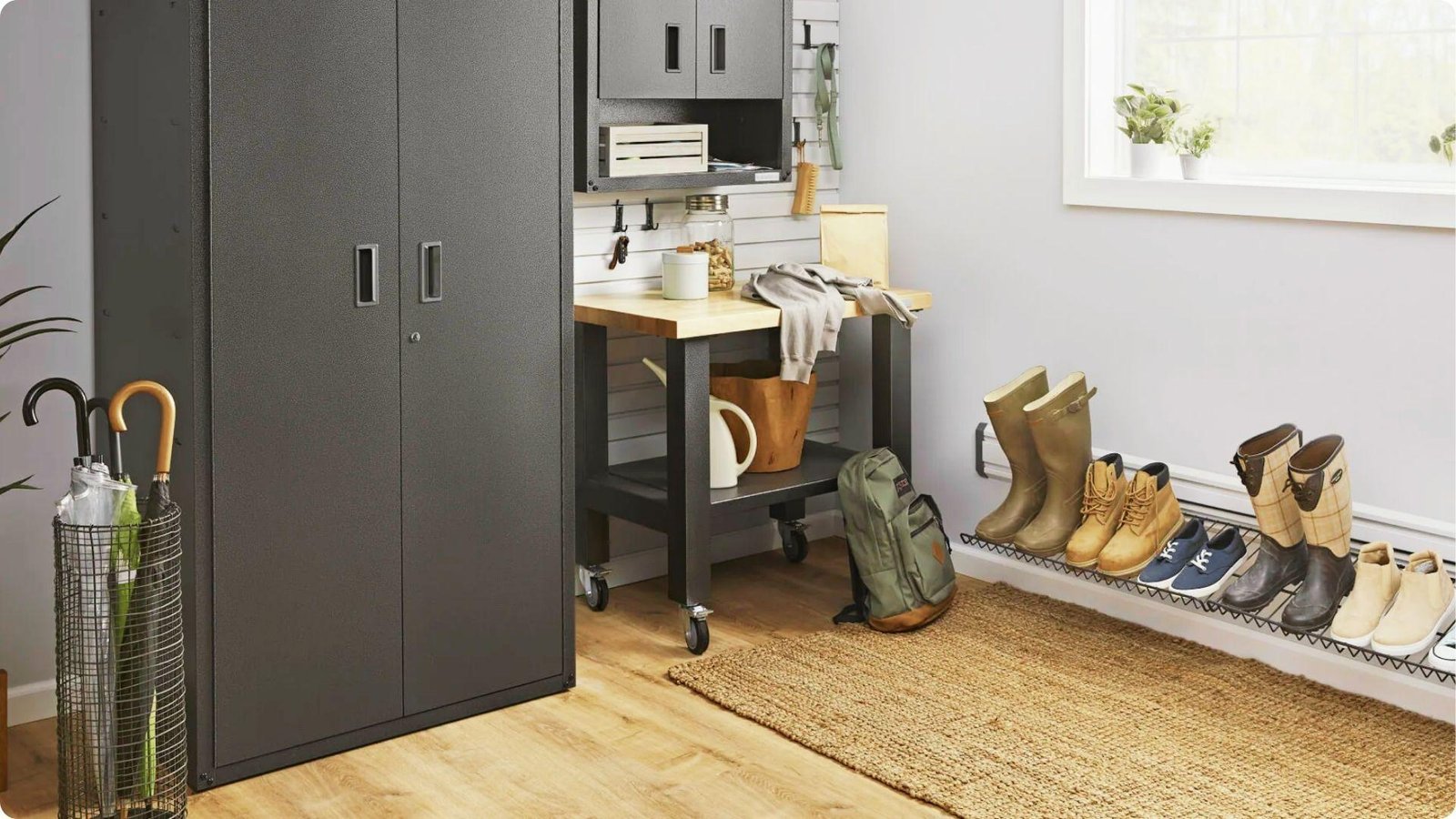Functional garage entryway with tall black metal cabinets, rolling workbench, and wall-mounted shoe rack.