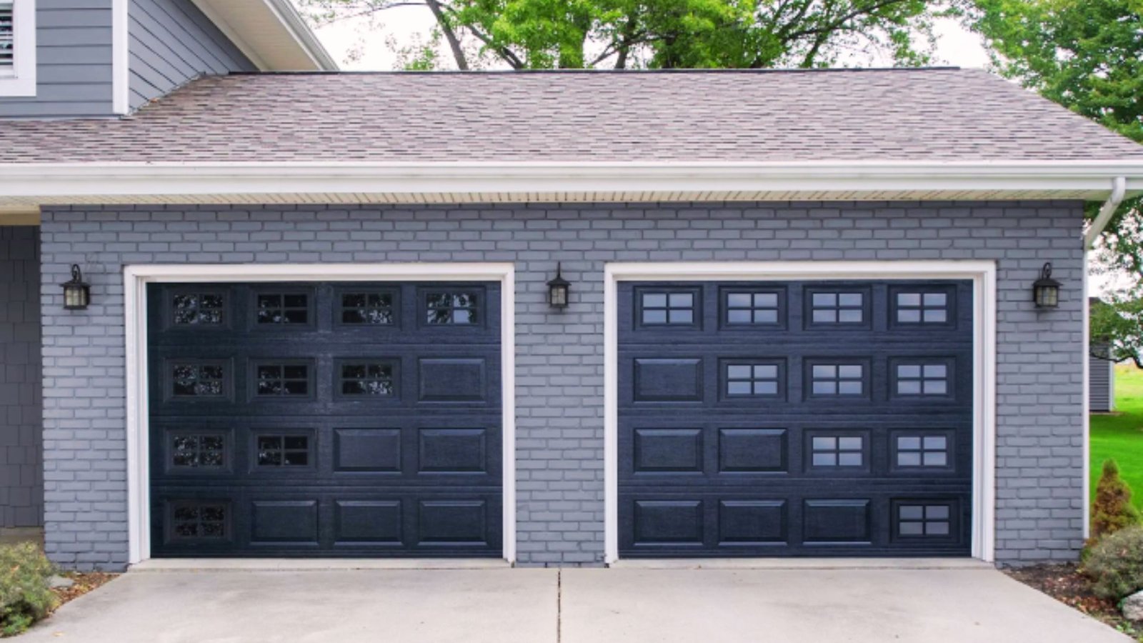Grey siding paired with a black garage door on a modern home exterior.