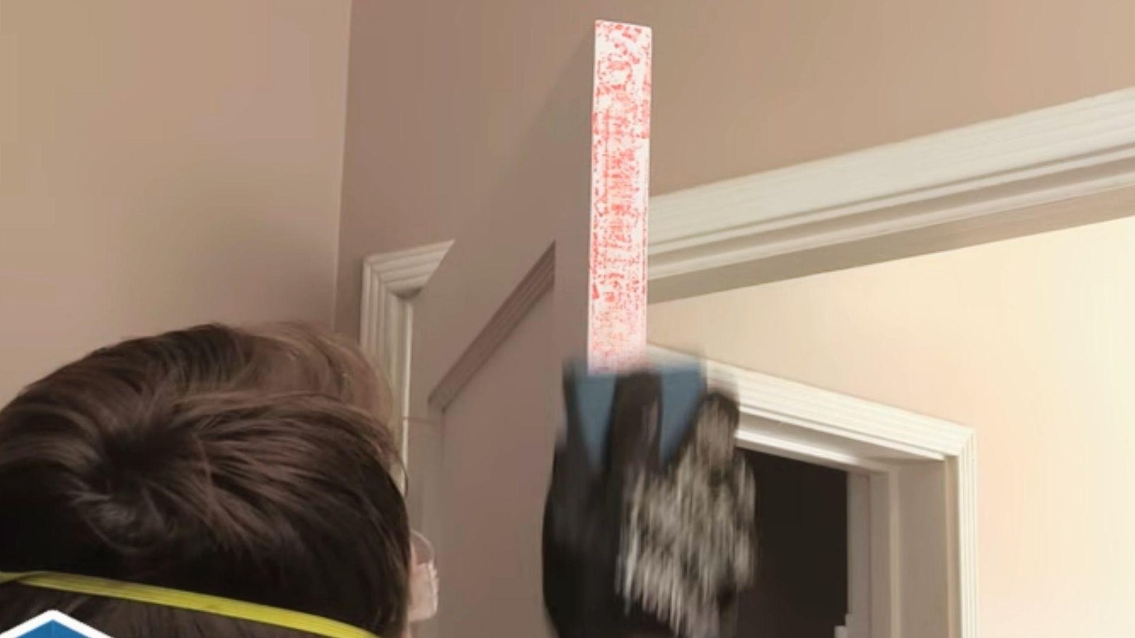 Sanding the chalk-marked edge of a door to remove excess material and eliminate sticking.